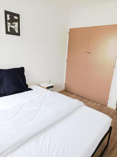 une chambre avec un lit blanc et un placard dans l'établissement Chambre avec lit double, à Besançon