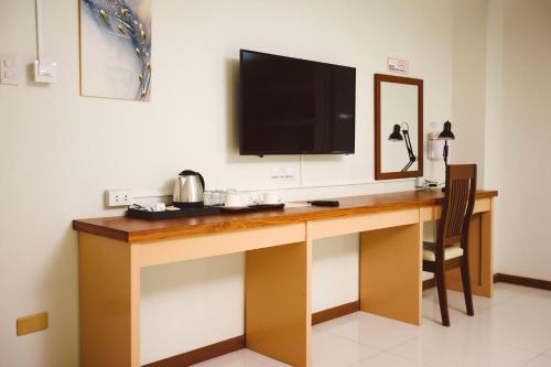 a desk with a television on top of it at Surigao Royal Regency Suites in Surigao