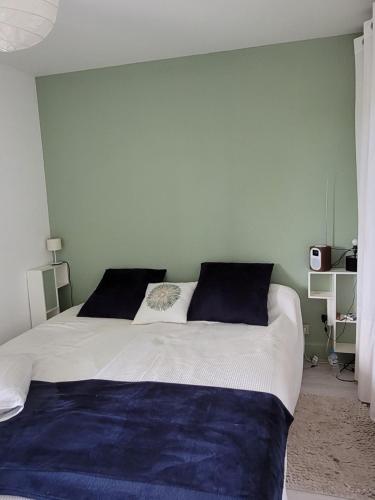 une chambre avec un grand lit blanc avec des oreillers bleus dans l'établissement NAUZAN PLAGE de VAUX SUR MER, à Vaux-sur-Mer