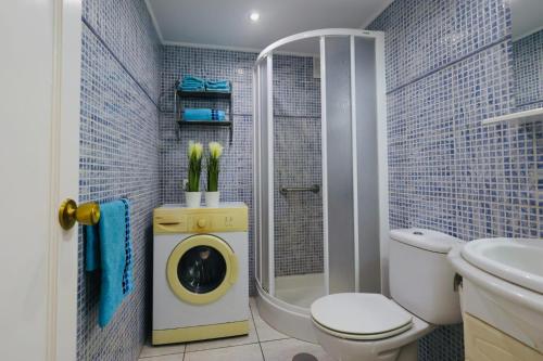 a bathroom with a toilet and a washing machine at Playa del Cura - Mar Paraiso in Playa del Cura