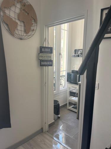 un couloir avec une porte et un panneau indiquant le sommet de l'hôtel georgetown dans l'établissement Lovely Cosy Studio Nice, à Nice