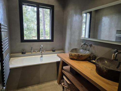 La salle de bains est pourvue de 2 lavabos, d'une baignoire et d'une fenêtre. dans l'établissement Maison l'Oasis 8 personnes piscine, à La Ciotat