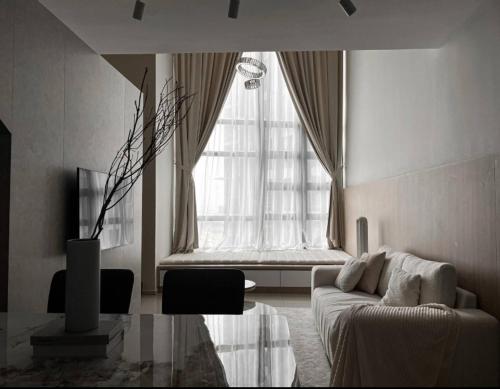 a living room with a couch and a large window at Loft Suite Eko Cheras in Kuala Lumpur