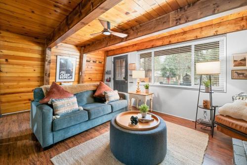 a living room with a blue couch and a table at Moonridge Manor Modern, Cozy Retreat with Hottub! in Big Bear Lake