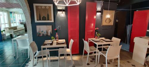 a dining room with two tables and chairs and red walls at Mecasa Hotel in Boracay