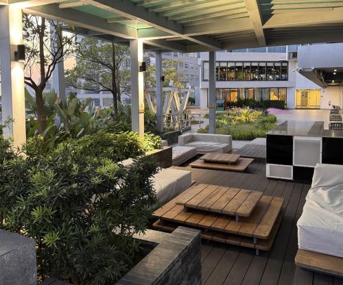 an outdoor patio with couches and tables on a building at Elegant 1BR with Great View, Panoramic Pool Near Ortigas CBD - 24 in Manila