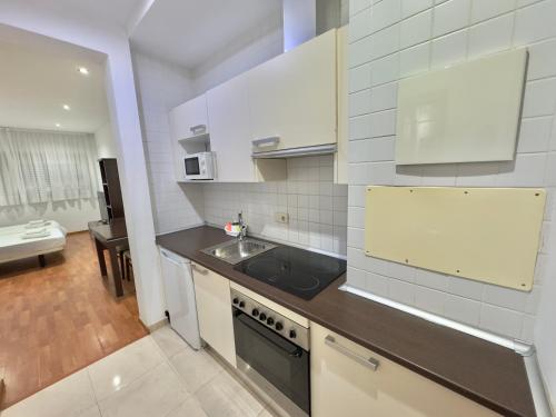 a small kitchen with a sink and a stove at ApartHome Domocenter in Bormujos