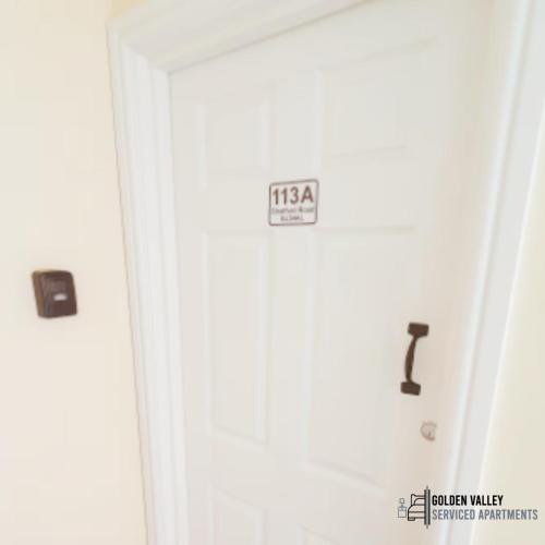 a white door with a sign on it at White Jasmine In Stroud in Stroud
