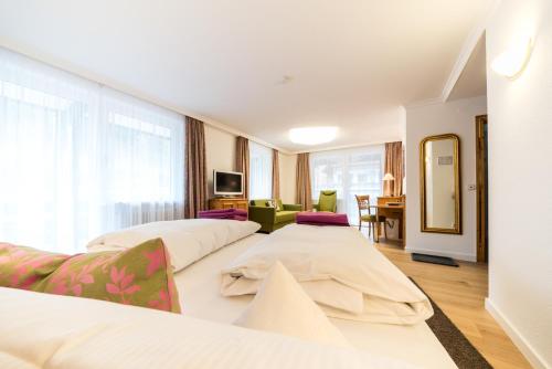 a hotel room with two beds and a mirror at Naturparkhotel Adler in Wolfach
