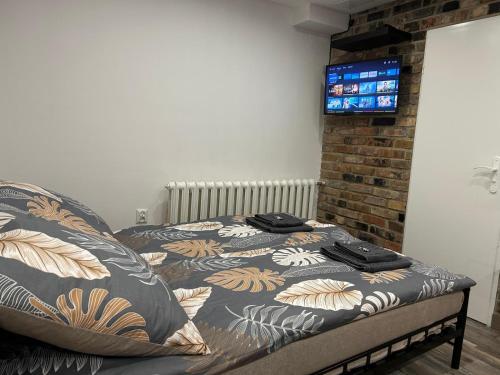 a bedroom with a bed with a tv on the wall at Cherry Street Apartment in Wolsztyn