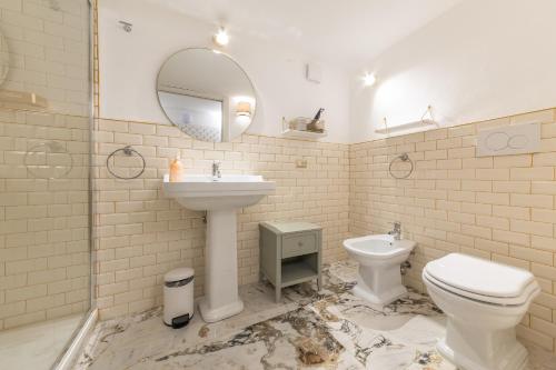 a bathroom with a sink and a toilet and a mirror at Duomo Smart Suites in Milan
