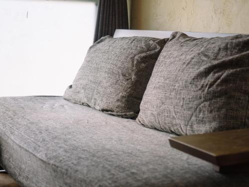 a bed with two pillows on top of it at お宿のごえん in Shijonawate