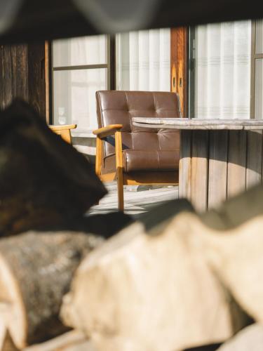 a brown leather chair in a room with a table at お宿のごえん in Shijonawate