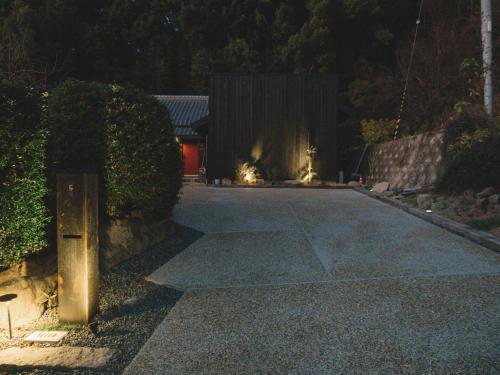 a driveway at night with a house with a fire at お宿のごえん in Shijonawate