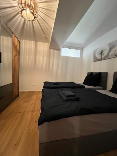 a bedroom with a large bed and a chandelier at traumhafte Business & Relax Wohnung direkt im Stadtkern Oettingens by Elation Homes in Oettingen in Bayern