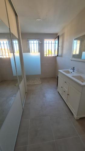 une grande salle de bain avec un lavabo et un miroir dans l'établissement clamart, à Sanary-sur-Mer