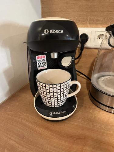 a coffee maker on a counter with a cup of coffee at traumhafte Business & Relax Wohnung direkt im Stadtkern Oettingens by Elation Homes in Oettingen in Bayern
