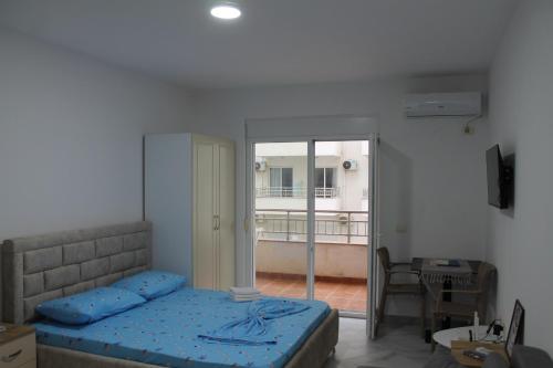 una camera da letto con letto e vista su un balcone di Djonis Rooms a Shëngjin