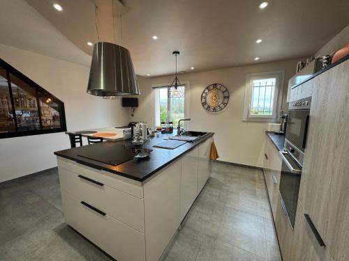 a kitchen with white cabinets and a counter top at Le Repaire des Bolides - 24H du Mans - 6p - Wi-Fi in Beaufay