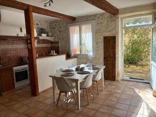 une cuisine avec une table et des chaises dans une pièce dans l'établissement Au cœur Maussanais, à Maussane-les-Alpilles