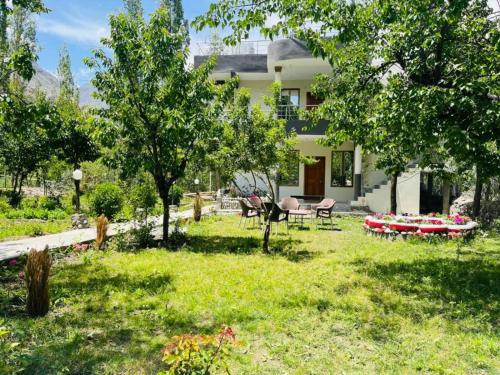 a house with a yard with a table and chairs at Pacific Guest House Skardu in Skardu