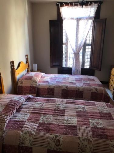 una camera da letto con due letti e una finestra di EVA & TRAVEL - El Cor del Montsant a Ulldemolins