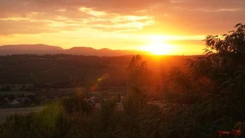 a sunset with the sun setting in the distance at Őzgida vendégház in Egerszalók