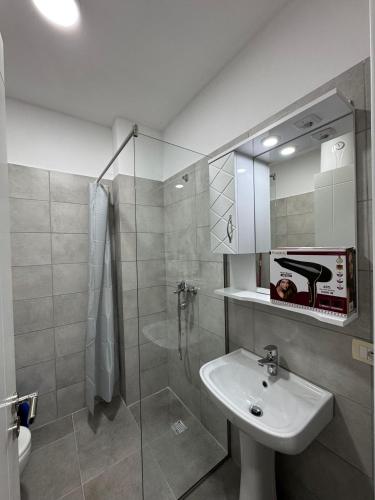 un bagno con lavandino e doccia in vetro di Djonis Rooms a Shëngjin