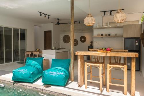 ヌサドゥアにあるSpring Villa Nusa Duaのテーブルと椅子のあるキッチンとリビングルーム