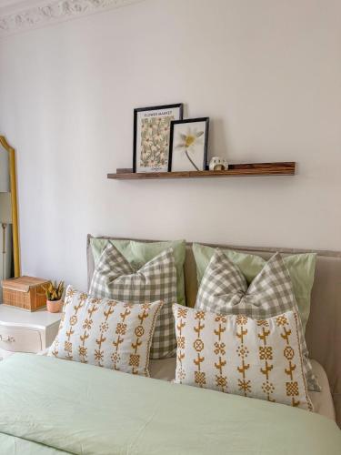 - un canapé avec des oreillers et une étagère sur le mur dans l'établissement Parisien Élégant & Calme, à Paris