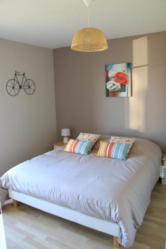 une chambre avec un grand lit avec des oreillers dessus dans l'établissement l' Huîtrier-Pie, à Saint-Valery-sur-Somme