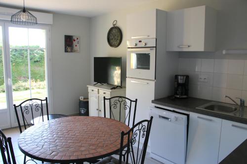 - une cuisine avec une table, une table et des chaises dans l'établissement l' Huîtrier-Pie, à Saint-Valery-sur-Somme