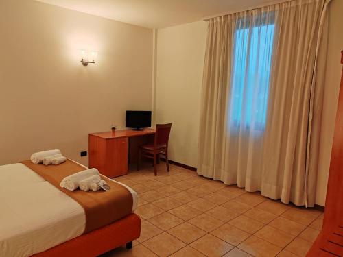 a hotel room with a bed and a desk with a computer at Niji Hotel&Restaurant in Mapello