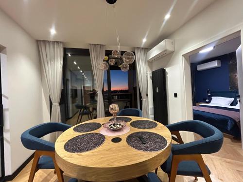 a dining room table with chairs and a bedroom at Blue Iris, 2BR, Stunning Views, Jacuzzi and Workspace in Sofia