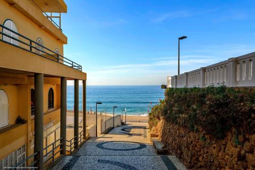 a walkway next to a building and the beach at Apartamento Praia de Santa Cruz - Casa Mar in Silveira