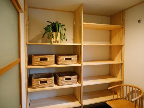 a book shelf with baskets and a plant on it at お宿のごえん in Shijonawate