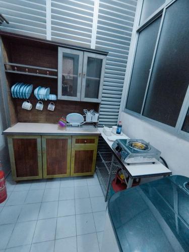 a kitchen with a stove and a counter top at Amna Homestay Sandakan in Sandakan