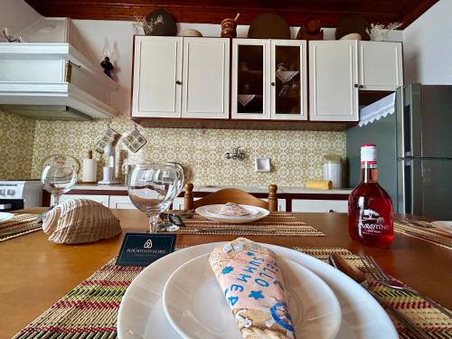 a kitchen with a table with a plate and wine glasses at BlueSunnyParadise in Glóssa