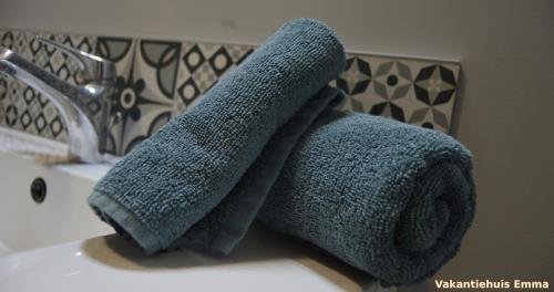 un rouleau de serviettes posé sur un lavabo de salle de bain dans l'établissement Vakantiehuis Emma Monflanquin, à Monflanquin