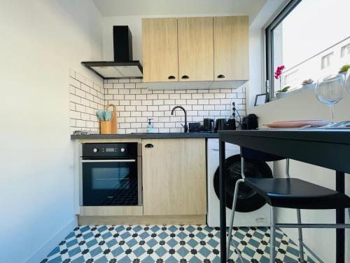 une petite cuisine avec un évier et une cuisinière dans l'établissement Le séjour du Général - 375, à Rouen