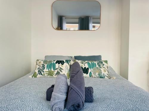 une personne avec les pieds sur un lit avec un miroir dans l'établissement Le séjour du Général - 375, à Rouen