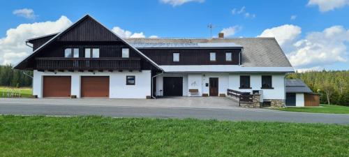 a large white house with a black roof at Horská Kvilda - Ubytování U Chvalů in Horská Kvilda