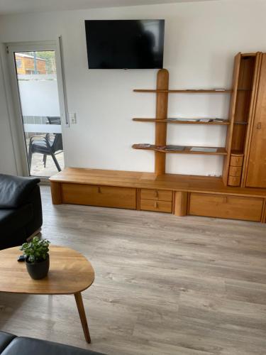 a living room with a tv and a wooden entertainment center at Ferienwohnung Rottal, Oberrot in Oberrot