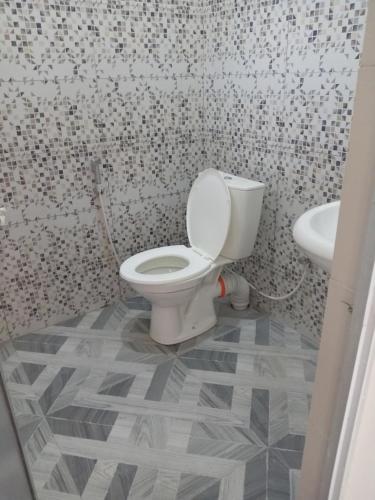 a bathroom with a toilet and a sink at Sun City Family Inn in Hatton
