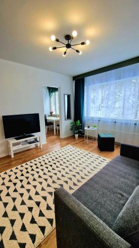a living room with a couch and a flat screen tv at Rentoudu Tässä in Lahti