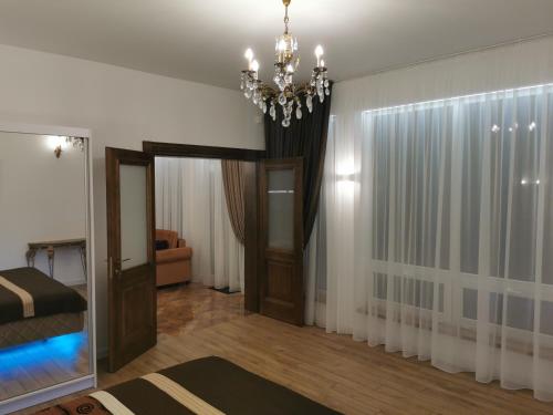 sala de estar con lámpara de araña y dormitorio en Beach Lounge Luxory Apartments, en Melnragė