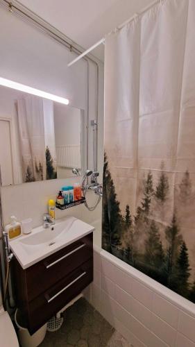 a bathroom with a sink and a shower at Rentoudu Tässä in Lahti