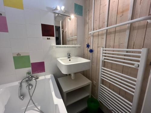 une salle de bain avec un lavabo et une baignoire dans l'établissement Séjour nature et détente dans la pinède, à Lège-Cap-Ferret