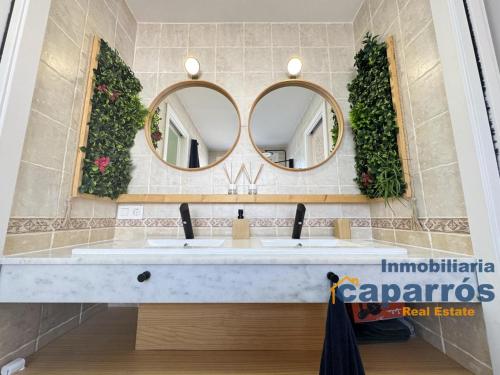 ein Badezimmer mit zwei Waschbecken und zwei Spiegeln in der Unterkunft Chalet El Coto Vera Playa, Tres dormitorios, Urbanización Piscina, Terraza, Sótano, Garaje in Vera