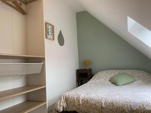 une petite chambre avec un lit et un escalier dans l'établissement Cottage cosy avec jardin, piscine et parking, à Cabourg